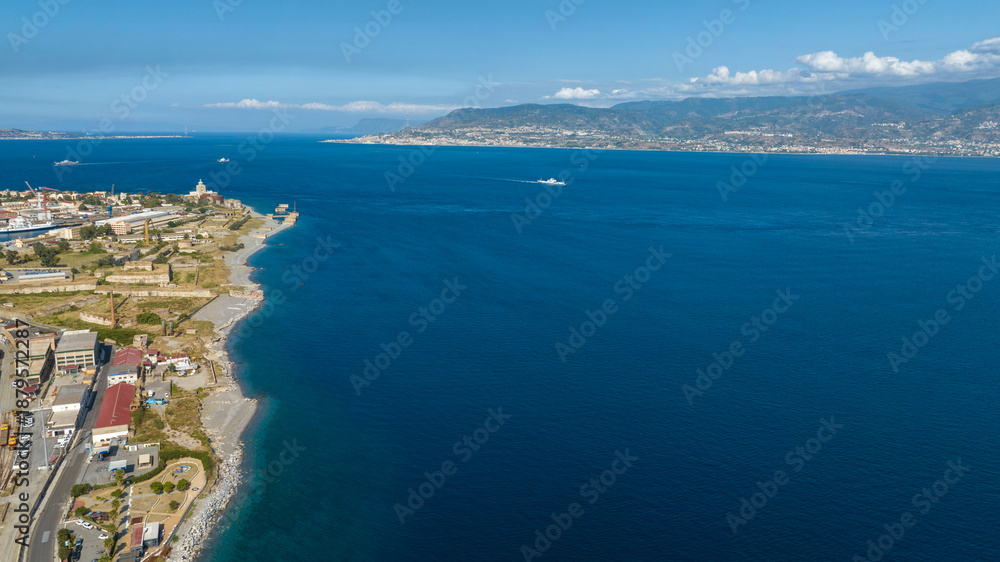 Fototapeta premium Aerial panorama of the Strait of Messina. It is a narrow strait between the eastern tip of Sicily and the western tip of Calabria, in Southern Italy. It connects the Tyrrhenian Sea with the Ionian Sea