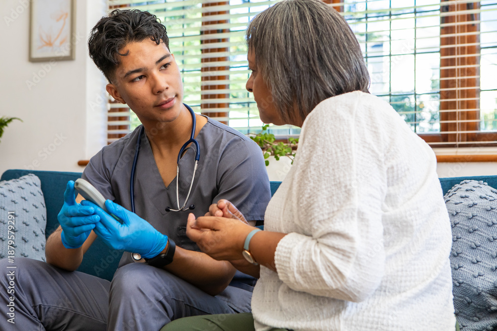 Fototapeta premium Asian medical assistant wearing stethoscope and gloves using glucometer checking senior patient