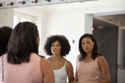 Fotografie Mother and daughter standing at bathroom dressing area in front of vanity mirror