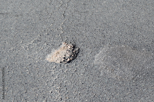 deep small round pothole in the street