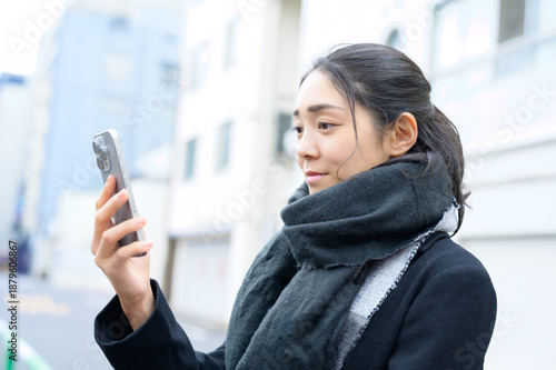 Wallpaper Mural マフラーをしてスマホを使用する日本人女性 Torontodigital.ca