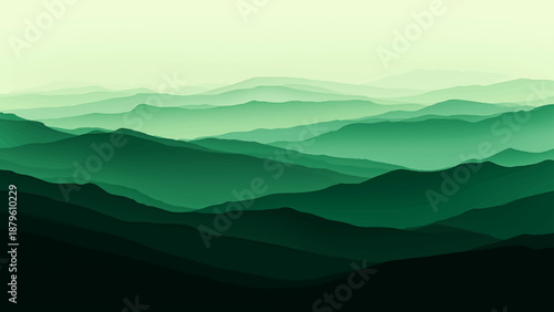 Misty mountain landscape with clouds and silhouettes of hills at sunrise over a blue valley horizon