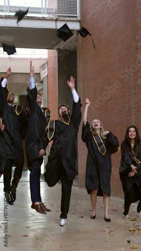 University students celebrating graduation by tossing caps