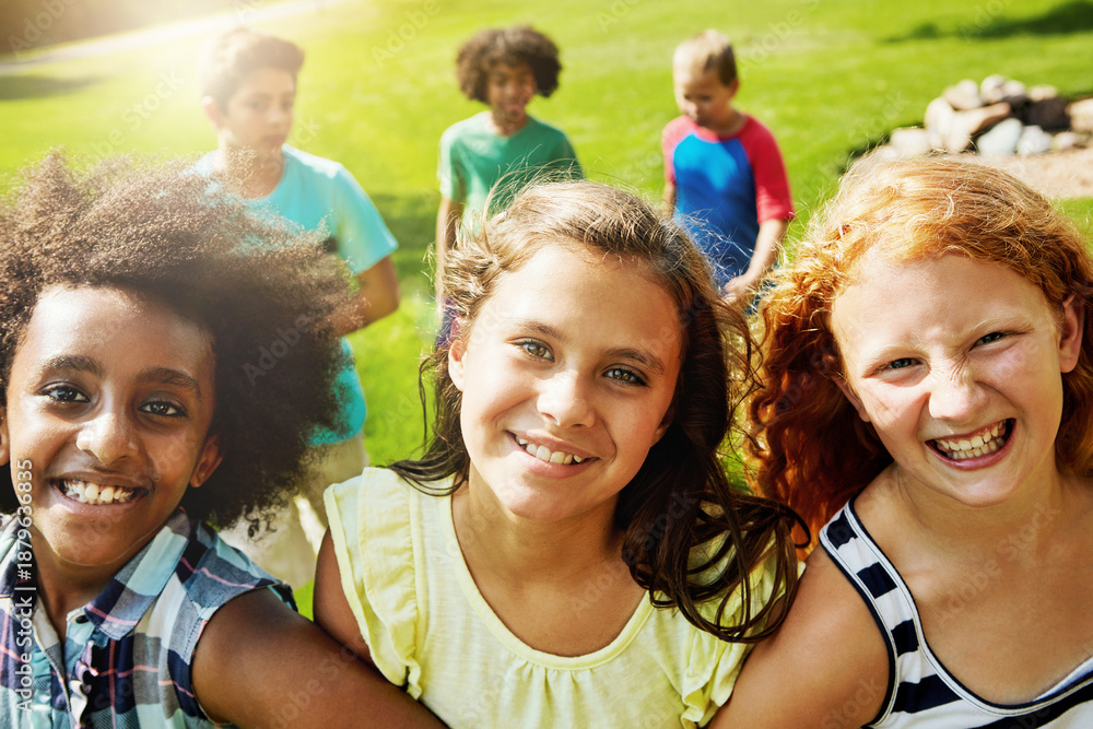 Obraz premium Friends, girls and kids at park with smile, diversity and bonding together with support on vacation. Happy children, group and portrait in nature with trust, care and students on holiday break