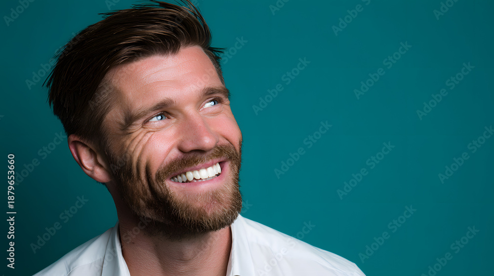 Fototapeta premium Man Smile Optimistically Against a Vibrant Teal Backdrop, Radiating Positivity and Hope, Making It Ideal for Motivational, Inspirational, and Lifestyle Content