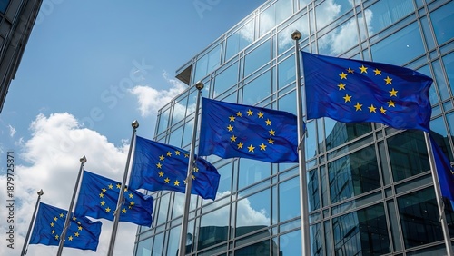 European Union Flags Waving in Front of Modern Glass Building.