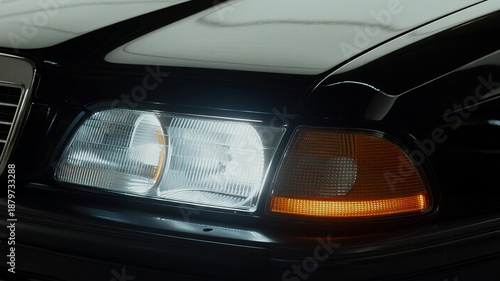 a future ultra-luxury sedan, headlights glowing softly in warm white tones