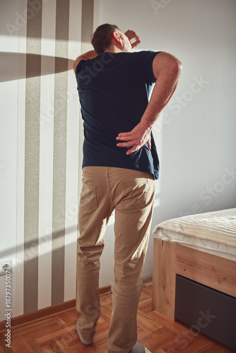 Wallpaper Mural Man with hip, back, spine and sciatica pain at home. Torontodigital.ca