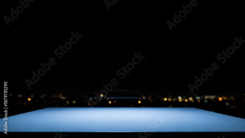 Sleek illuminated blue platform glowing in darkness, with a blurred distant city lights backdrop, forming a modern abstract stage for innovative concepts and future presentations