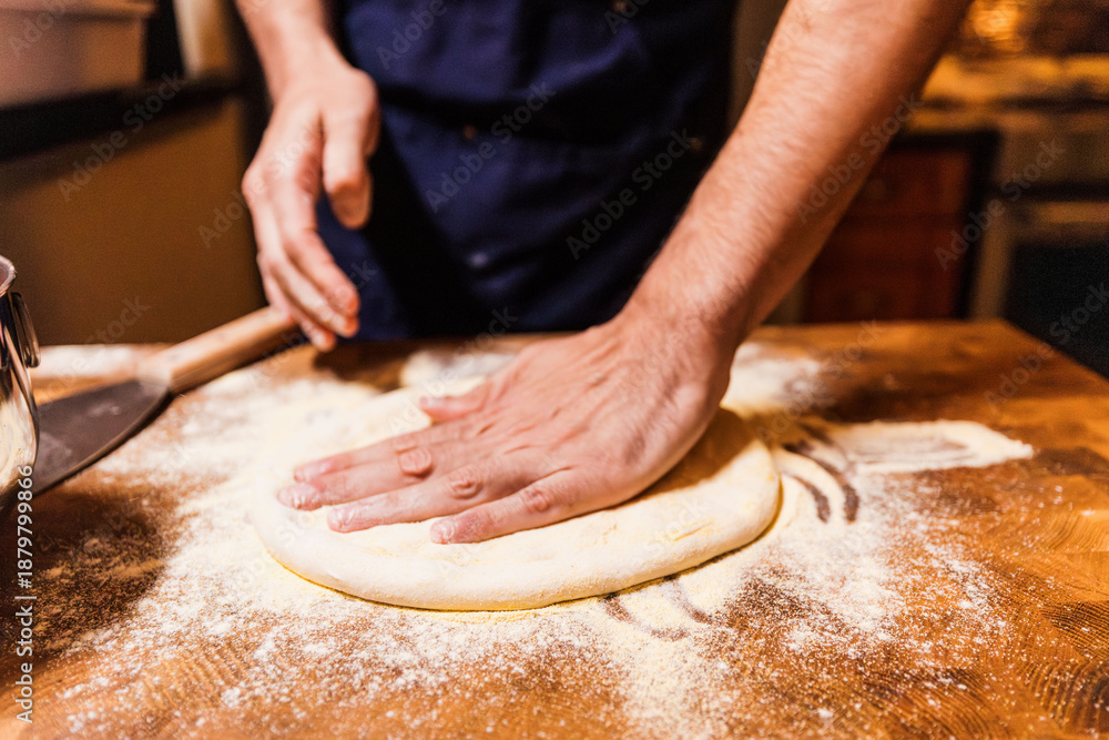 Ταπετσαρία Baker's hands flatten sourdough dough on flour-dusted wooden cutting board durin