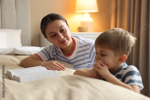 Mother and her daughter with Bible at home