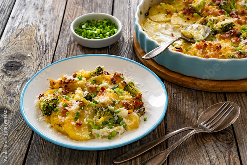 Potato broccoli casserole - baked potatoes with broccoli, cheddar cheese and smoked bacon on wooden table	
