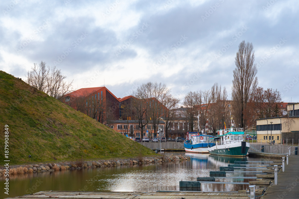 Fototapeta premium Scenic City Canal with Docked Boats and Modern Architecture