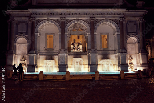 Tableau sur toile Nighttime illuminated Fontana dell'Acqua Paola in Rome, floodlights highlighting Baroque facade, arched niches, papal coat of arms, statues, cascading basins and glowing water