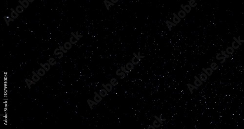 Natural organic dust particles floating dynamically in space against a black background. Shimmering glittering dust with bokeh. This dust is in slow motion.