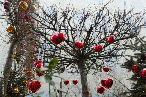 Foto Red heart-shaped ornaments decorate the trees in a festive setting