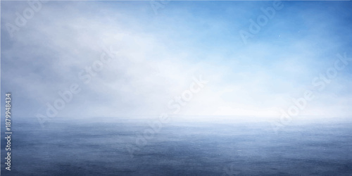 A calm blue sky with white clouds hangs over the tropical ocean horizon as gentle summer waves meet the light on this beautiful sunny seascape