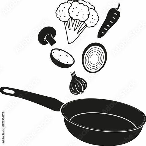 Fresh vegetables falling into a frying pan preparing a healthy meal