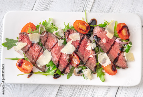 Tableau sur toile Italian beef tagliata salad with arugula and balsamic glaze on white plate