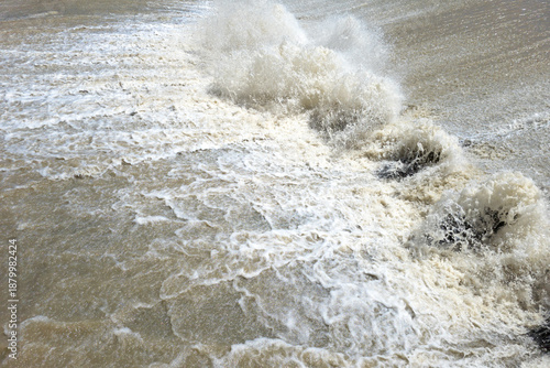 Billede på lærred Powerful water splashes and churns vigorously in a natural outdoor setting