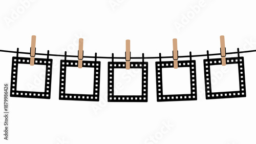 Empty film frames hang on a black clothesline with wooden clothespins