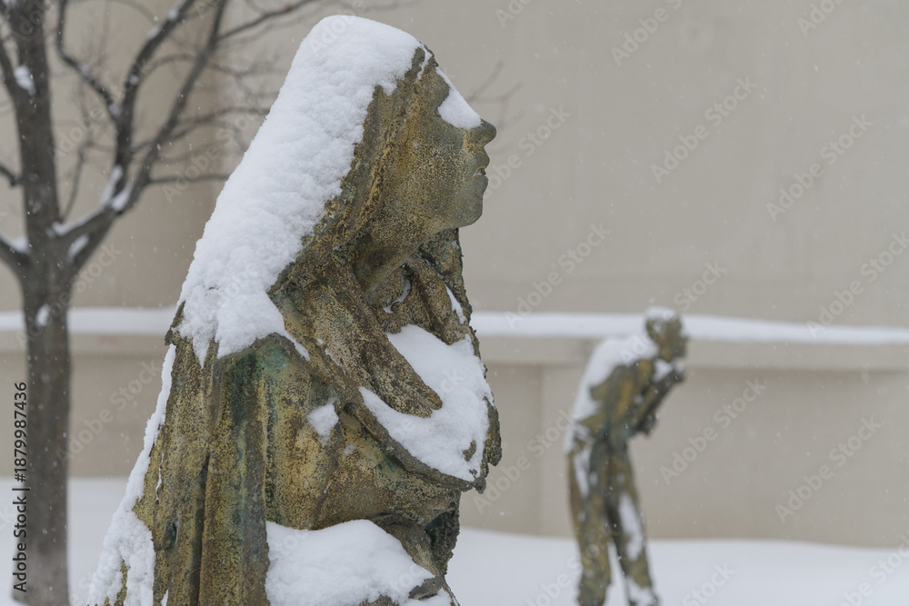 Fototapeta premium Pregnant Woman created by Irish artist Rowan Gillespie part of The Arrival, set beside the old Canada Malting silos on Eireann Quay, Toronto, during winter storm on 2026-01-15