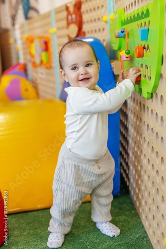 Happy baby playing with wall toy at daycare