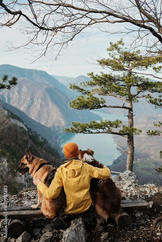 Woman hiking with a German and Australian Shepherd at Banjska Stena viewpoint in Tara National Park, Serbia, showing travel, hiking lifestyle and bond with pets in nature.