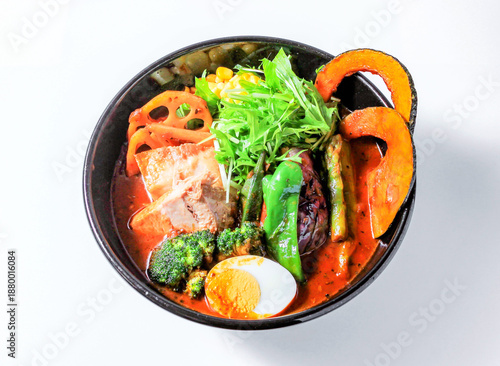 Delicious Pork curry spicy ramen bowl with vegetables and egg in bowl isolated on white background