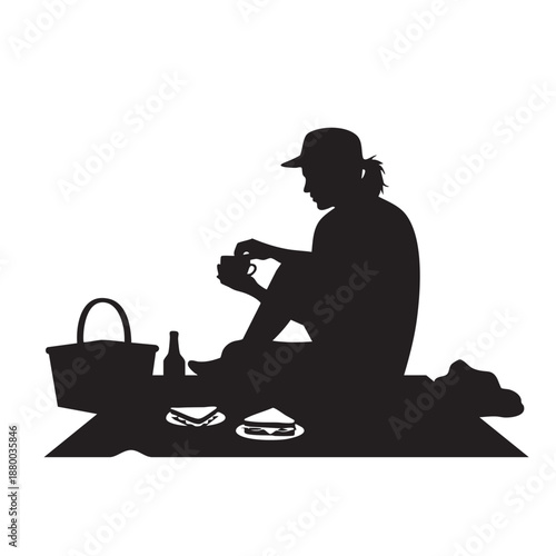 Silhouette man having picnic outdoors solo. Person enjoying meal on blanket, with basket, bottle, and sandwiches, relaxing in nature during a peaceful break.