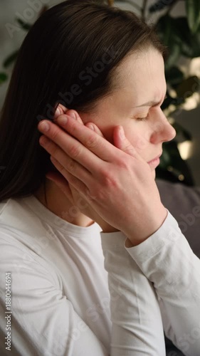 Wallpaper Mural Sick unhappy young caucasian female having ear pain touching painful head sitting on couch. Unhealthy tired woman suffering from painful otitis. Healthcare and tinnitus concept Torontodigital.ca