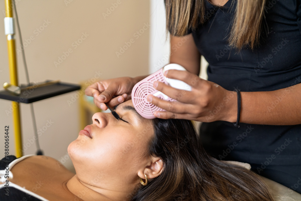 Fototapeta premium Lash artist applying individual eyelash extensions to client