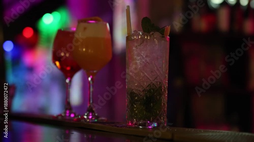 Three vibrant cocktails on a bar counter in colorful ambient lighting, creating a stylish, festive atmosphere perfect for nightlife, mixology, and modern bar promotions.