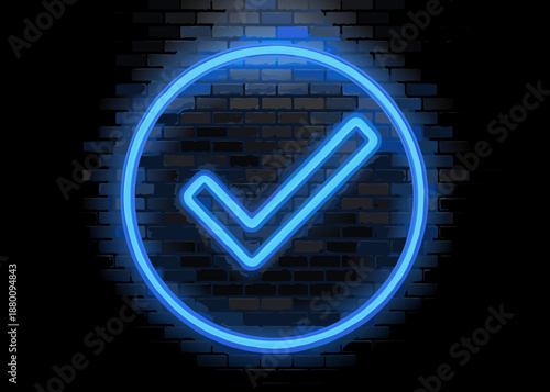 A bright blue neon check mark sign against a dark brick wall