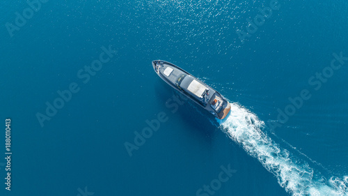 Bilde på lerret Seafaring Vessel: Aerial perspective of a sleek vessel navigating across a vast, tranquil expanse of ocean, leaving a wake