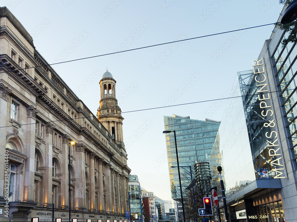 Fototapeta premium Busy Manchester Cross street scene featuring historic architecture and contemporary shopping center UK