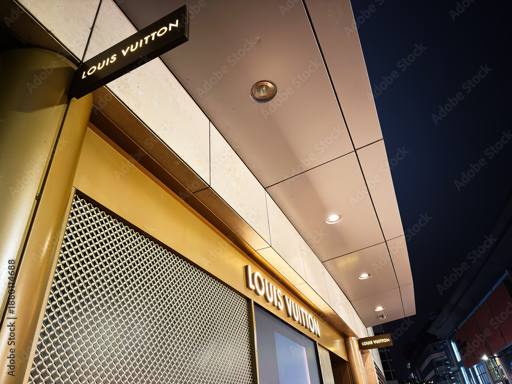 Fototapeta premium Louis Vuitton store exterior at night in Manchester showcasing luxury storefront and signage