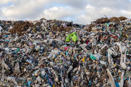 Foto Large mounds of garbage sit in a landfill site surrounded by debris and waste un