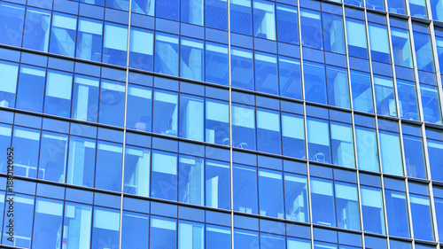 A modern tall building made of steel and glass, housing offices and financial institutions. Glass wall on the facade of the building.