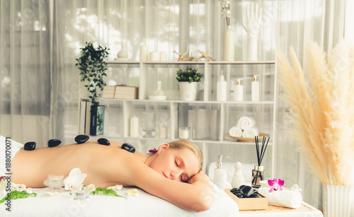 Obraz na plátne Hot stone massage at spa salon in luxury resort with day light serenity ambient, blissful woman customer enjoying spa basalt stone massage glide over body with soothing warmth
