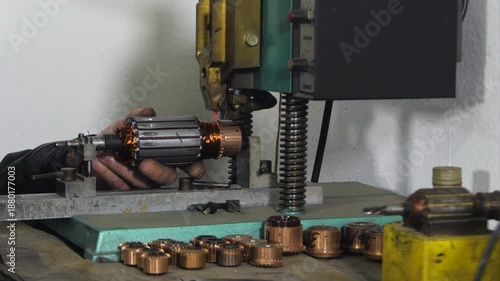 Hot staking process on commutator welding machine during rewinding electric motor in repair shop