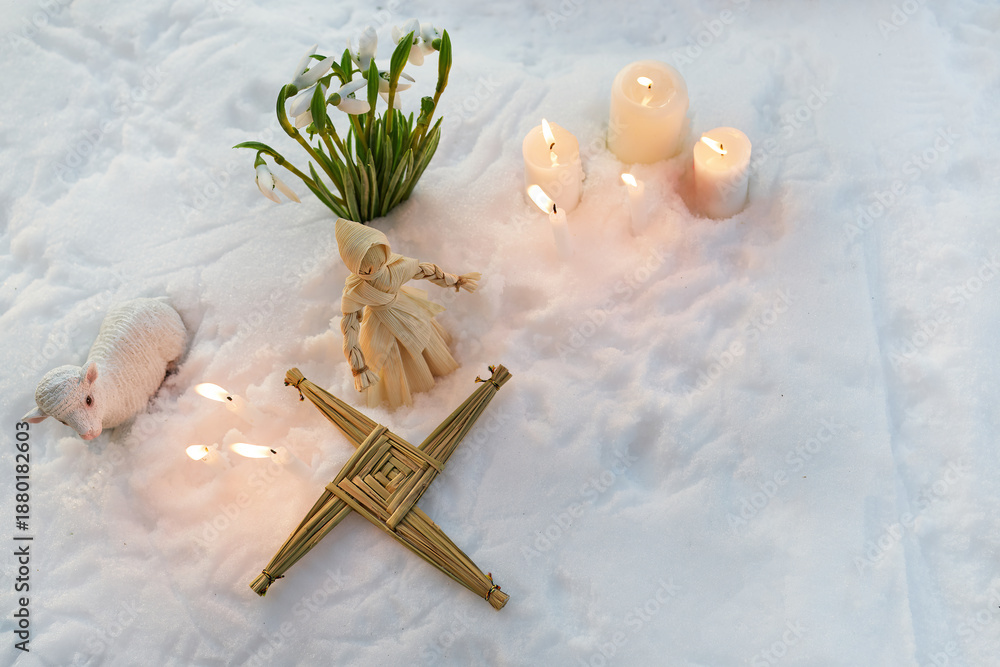 Fototapeta premium Imbolc celebration with brigid's cross, snowdrops, and candles in snow