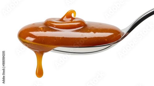 Salted caramel sauce on spoon isolated on white background, rich glossy texture and indulgent dessert concept.