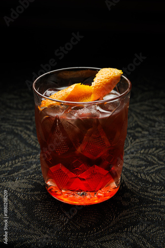 Slika na platnu Sipping a refreshing cocktail with orange peel garnish at a stylish bar during a