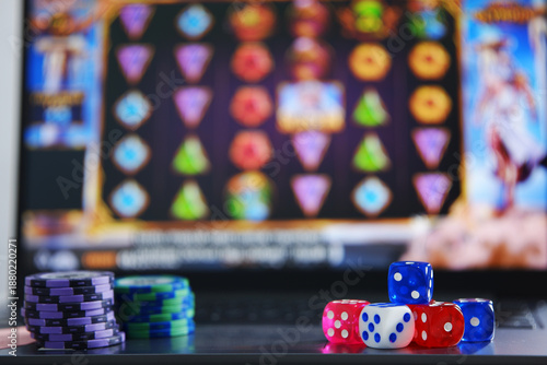Quadro em tela Dice and gambling token chips with an online slot gambling background on a laptop screen