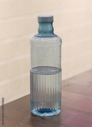 plastic bottle filled with water on a wooden table.