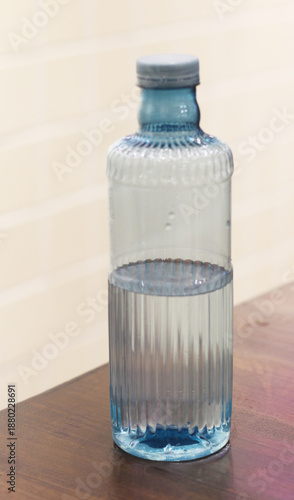 plastic bottle filled with water on a wooden table.