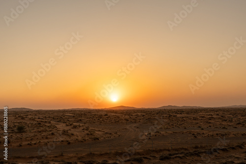 Foto A sunset displays a bright orange sky above a vast desert
