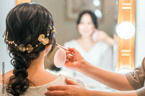 Fotografie Bride putting on makeup in the bridal room