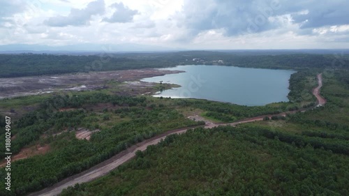 Aerial view of a former coal mining pit that holds water like a blue lake, environmental damage